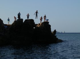 Boys jumping off rocks into the sea Costa Brava