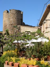 Tower on village wall at Ullastret with restaurant